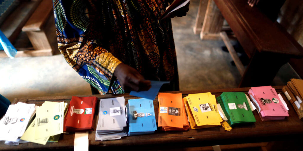 Une femme fait le choix de différents bulletins de votes lors de l'élection présidentielle au Cameroun