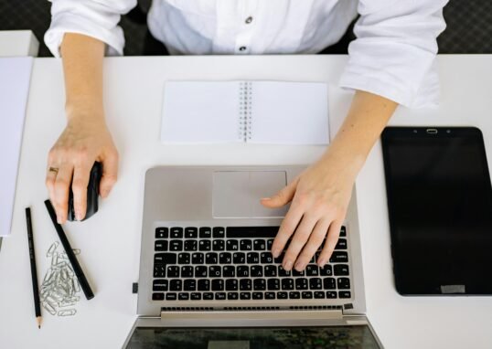 Mains sur un clavier pour suivre les AI Overviews