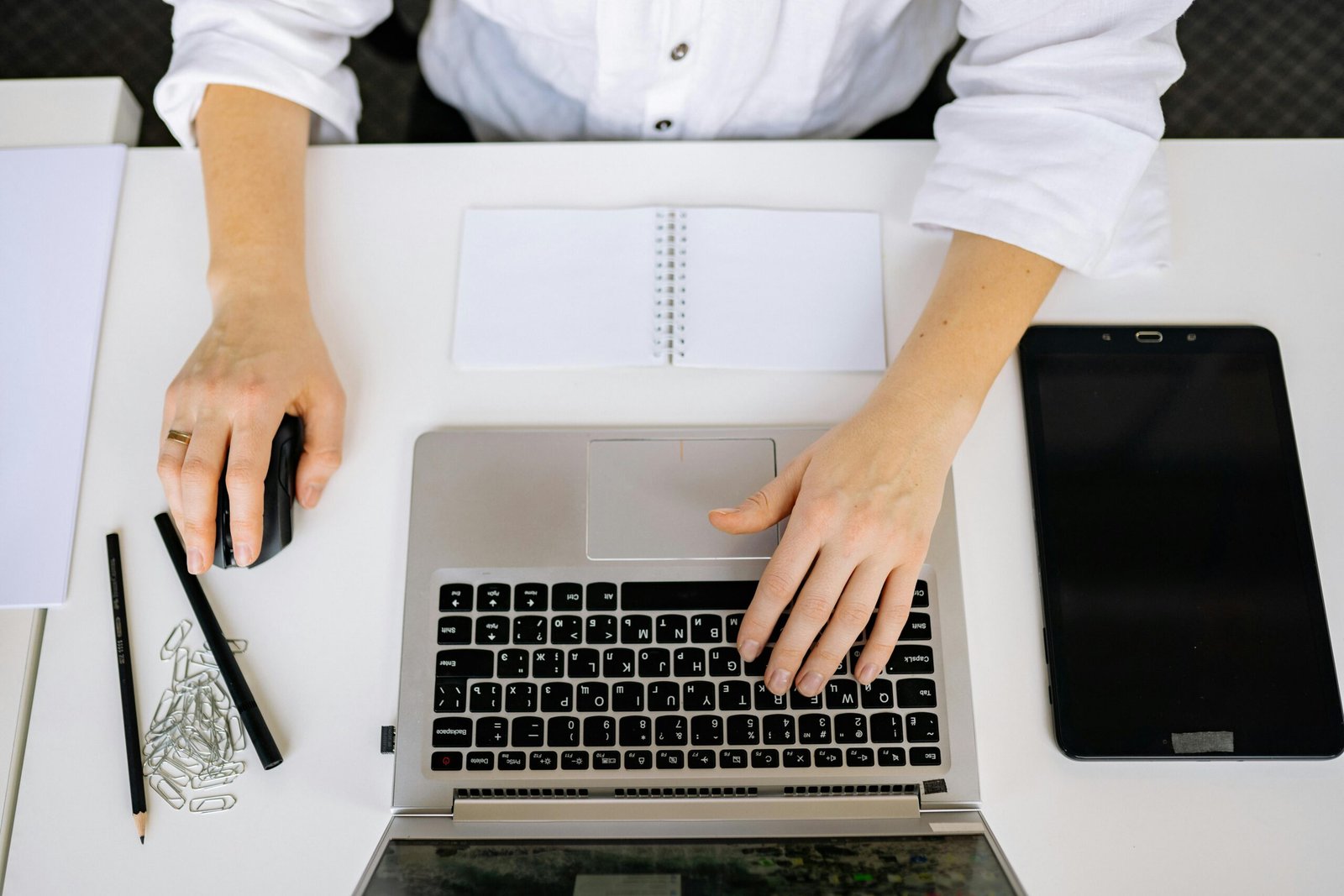 Mains sur un clavier pour suivre les AI Overviews